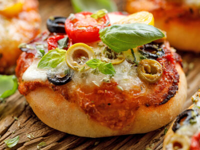 This easy mini pizzas recipe is super easy to make and versatile enough that everyone can have pizza exactly the way they like it! This is one of my kids' favorite recipes. It's super simple, they can make it themselves and everyone can have the toppings they want on their own mini pizzas.