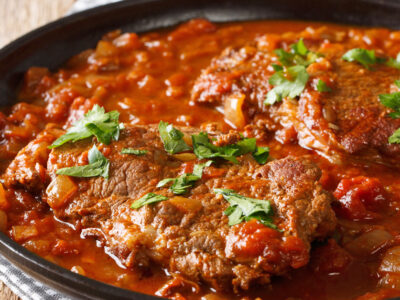 This easy Swiss Steak recipe makes a tasty meal that your family will love! It's easy to make in a skillet on the stovetop or in a crockpot! This post contains 2 Swiss steak recipes that can easily be cooked in the crockpot along with garlic green beans and coconut brownies!
